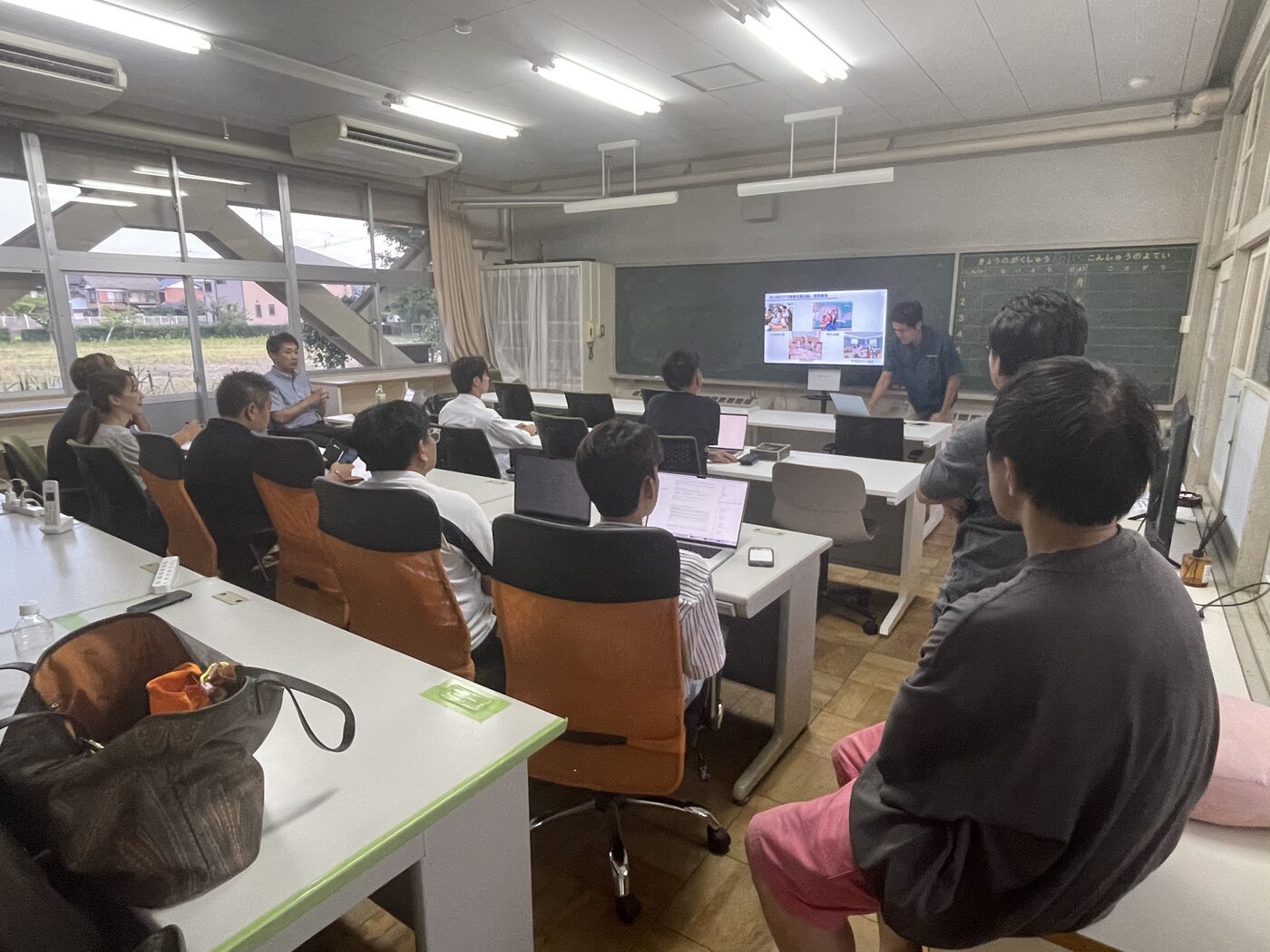 教室でスクリーンを見ながら講義を受けている様子